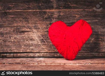 Red thread heart over old shabby background. Valentine concept