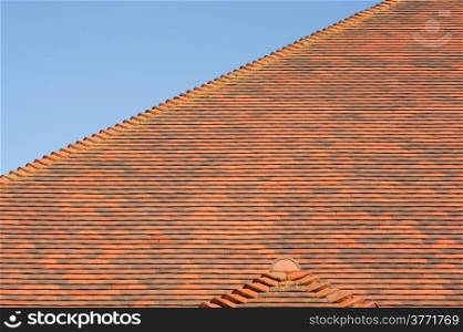 red tiled roof abstract with a blue sky background