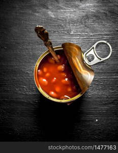 Red tinned beans. On a black wooden background.. Red tinned beans. On black wooden background.