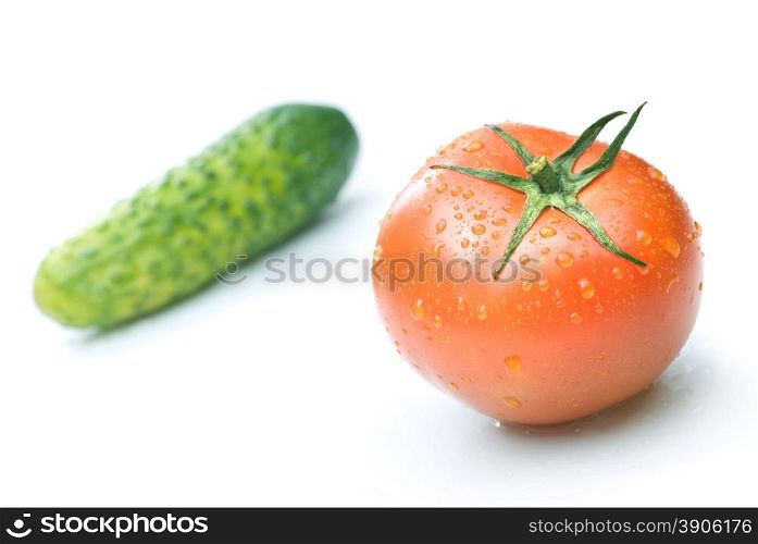 red tomato and green cucumber with water drops isolated on white