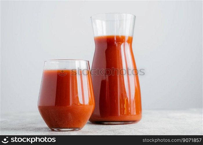 Red tomato juice in glass isolated over white background. Vegetable smoothie. Organic beverage. Horizontal shot. Healthy vitaminized drink