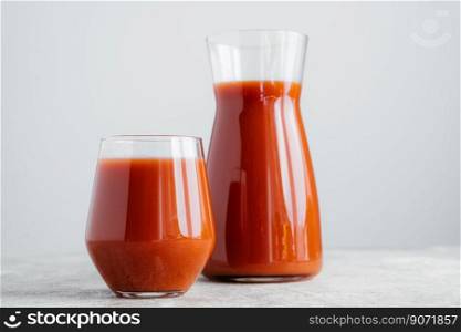 Red tomato juice in glass isolated over white background. Vegetable smoothie. Organic beverage. Horizontal shot. Healthy vitaminized drink