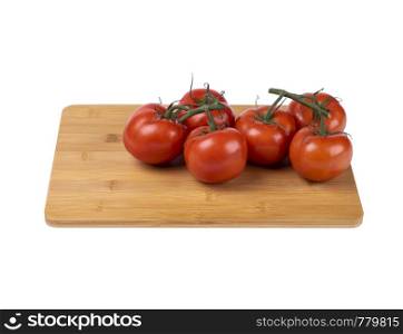 red tomatoes on a twig, lie on a wooden board, image on a white background