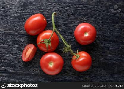 red tomatoes with green salad on dark wooden background. red tomatoes with green salad on wood