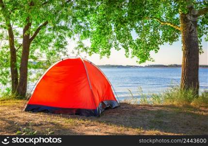 Red tourist tent on the lake in summer. Red tourist tent on lake in summer