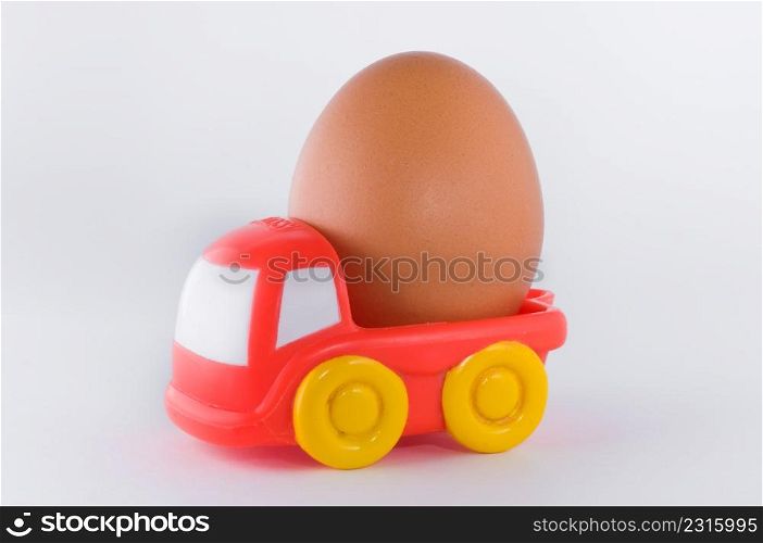 red toy truck loaded with an egg on white background