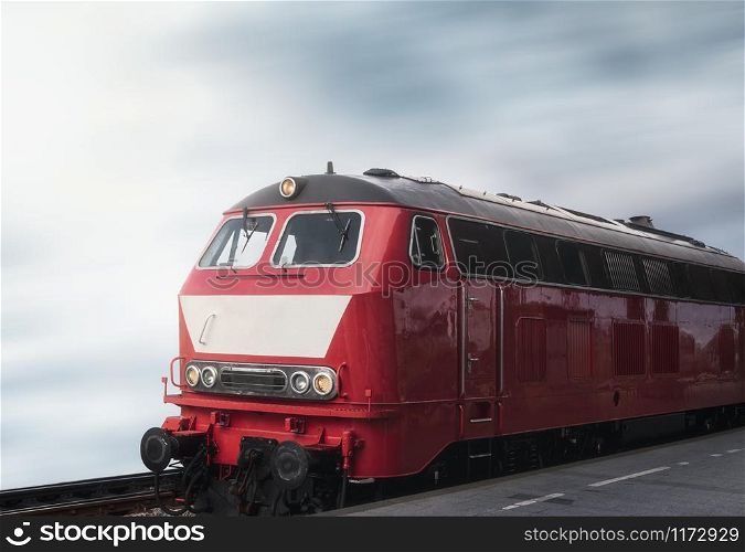 Red train locomotive on rail tracks and railway platform. Train travel concept. Retro train and railway station. German train locomotive.