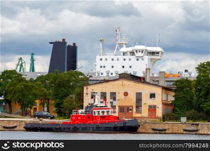 Red tug at the pier in the port of Gdynia.. Gdynia. Sea port.