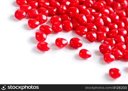 Red Valentine&acute;s cinnamon heart candies on white background