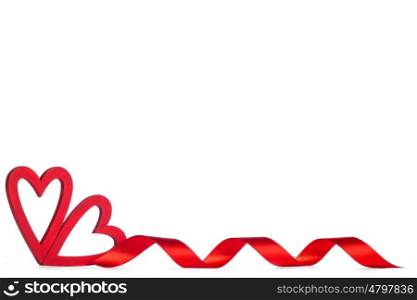 Red Valentine day hearts. Two wooden red painted Valentine day hearts and curly ribbon isolated on white background