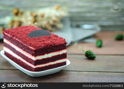Red velvet cake and white cream on wooden table, close up, space to write.