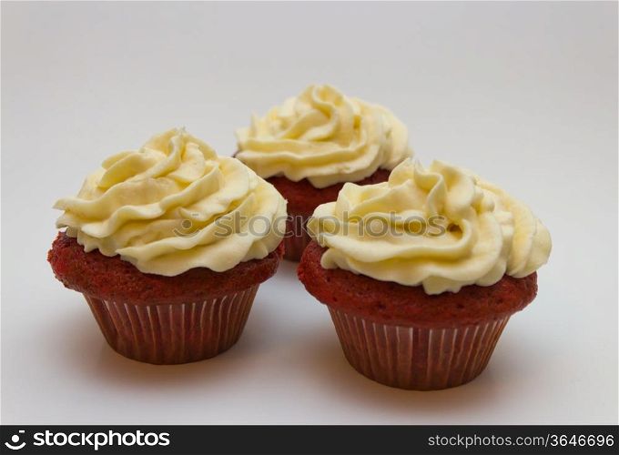 Red velvet cupcakes with buttercream icing isolated on white.