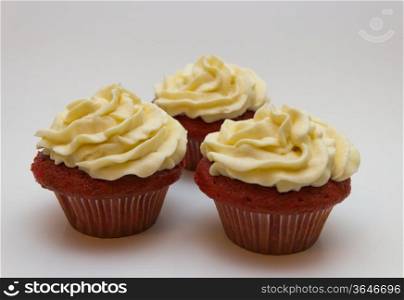 Red velvet cupcakes with buttercream icing isolated on white.