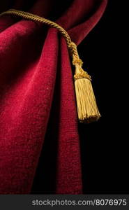 Red velvet curtain with tassel. Close up black isolated curtain