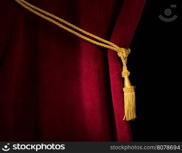 Red velvet curtain with tassel. Close up black isolated curtain
