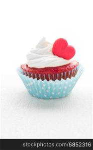Red velvet heart cupcake with cream cheese frosting and a red heart for Valentine&rsquo;s Day. White background with copy space