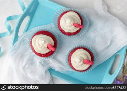 Red velvet heart cupcakes with cream cheese frosting and a red heart for Valentine's Day. Top view