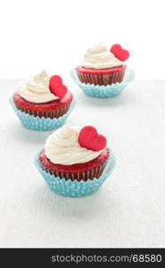 Red velvet heart cupcakes with cream cheese frosting and a red heart for Valentine's Day