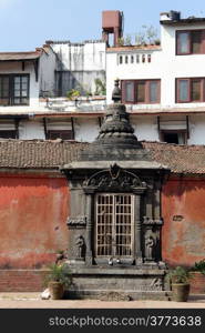 Red wall and small temple in Durbar square in Patan, Nepal