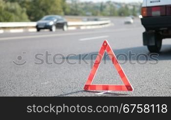 Red warning triangle with a broken down car