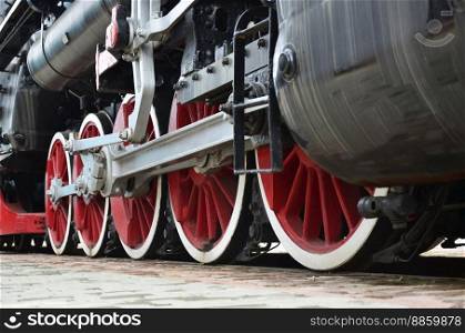 Red wheels of old USSR black steam locomotive. Wheels of an old soviet steam train. Red wheels of steam train