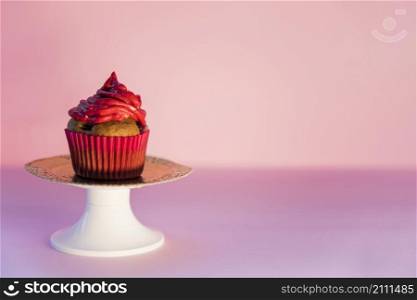 red whipped cream cupcake cakestand against pink backdrop