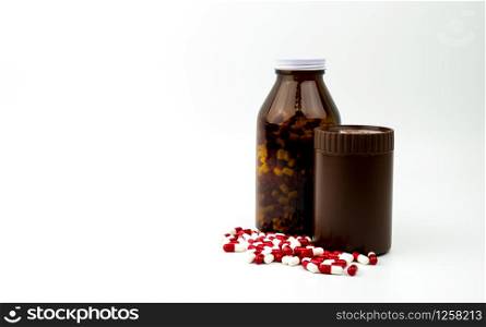 Red, white antibiotic capsules pills and two amber bottles isolated on white background with copy space and blank label. Drug resistance, antibiotic drug use with reasonable, health policy concept.