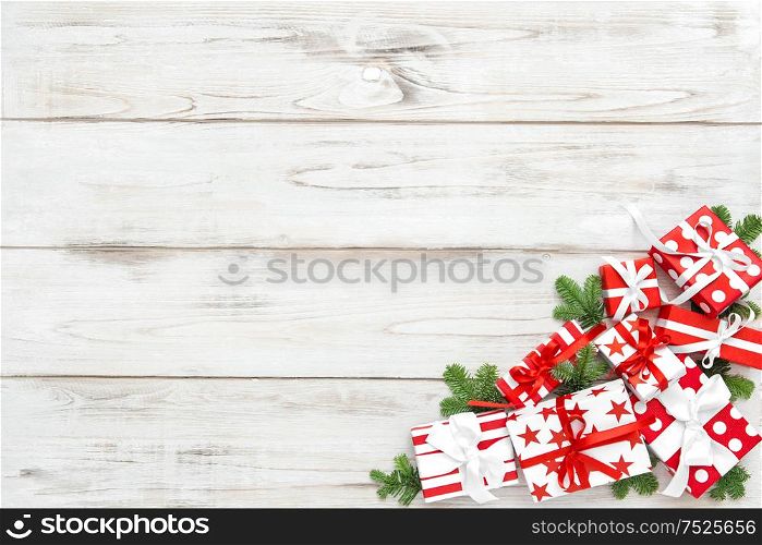Red white Christmas decoration and pine tree branches on wooden background. Holidays banner