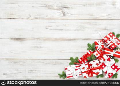 Red white Christmas decoration and pine tree branches on wooden background. Holidays banner