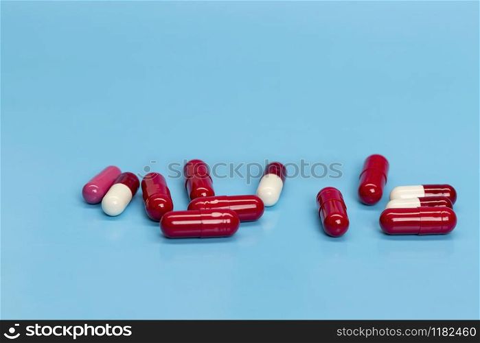 Red-white medicinal capsules on blue background