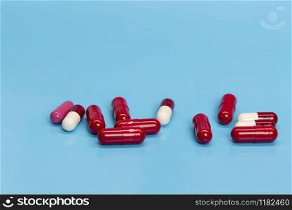 Red-white medicinal capsules on blue background