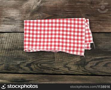 red-white textile kitchen towel on a wooden background from old gray boards, place for an inscription