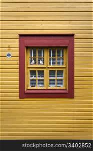 Red window on a yellow wall