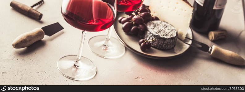 Red wine and cheese on concrete background, copyspace