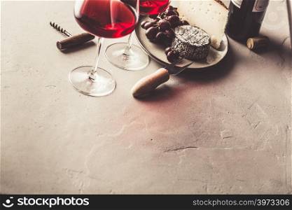 Red wine and cheese on concrete background, copyspace