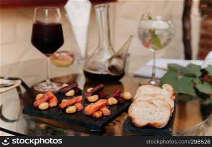 Red wine and cocktail with baguette bread, dried beef jerky, appetizer canape on dinner table