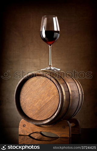 Red wine and glass with wooden barrel