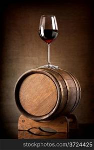 Red wine and glass with wooden barrel