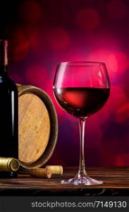 Red wine and wooden barrel on a burgundy bokeh background. Red wine on a bokeh background