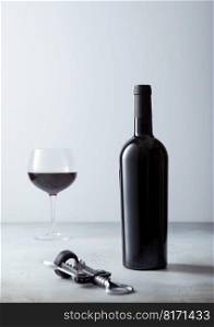 Red wine bottle and glass with black opener