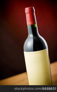 Red wine bottle on wooden table over dark red background