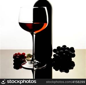 red wine glass and bottle with reflection
