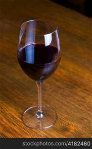 red wine glass over at wooden table background
