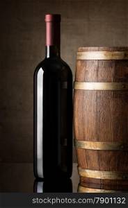 Red wine in a bottle near wooden barrel