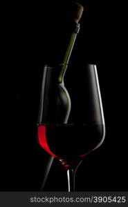 red wine in glass and bottle isolated on black