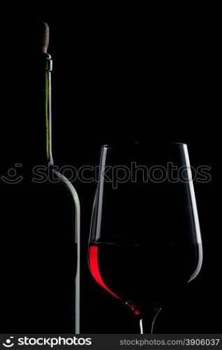 red wine in glass and bottle isolated on black
