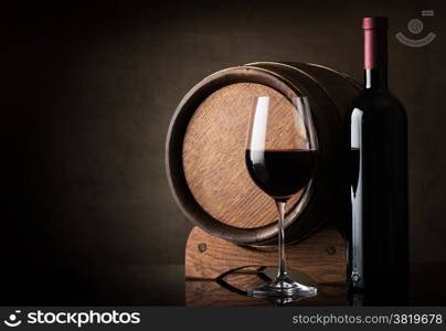 Red wine near wooden barrel on a brown background