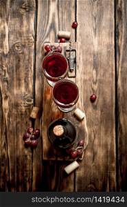 Red wine on wooden Board with stoppers and a corkscrew. On a wooden table.. Red wine on wooden Board with stoppers and a corkscrew.