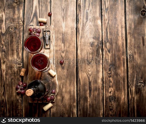 Red wine on wooden Board with stoppers and a corkscrew. On a wooden table.. Red wine on wooden Board with stoppers and a corkscrew.