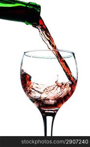Red wine pouring in glass. Isolated over white